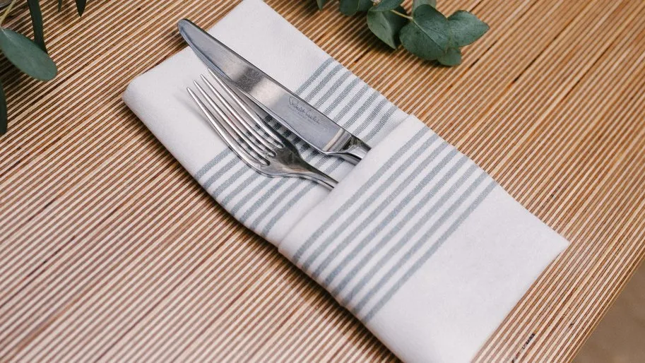 Eingedeckter Platz mit Stoffserviette und Besteck bei einem Catering-Einsatz
