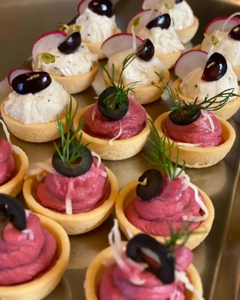 Kleine herzhafte Tartelettes mit Aufstrichen, Oliven und Radieschen garniert