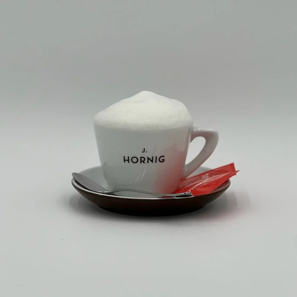 Cappuccino mit dichter Milchschaumhaube in weißer Tasse