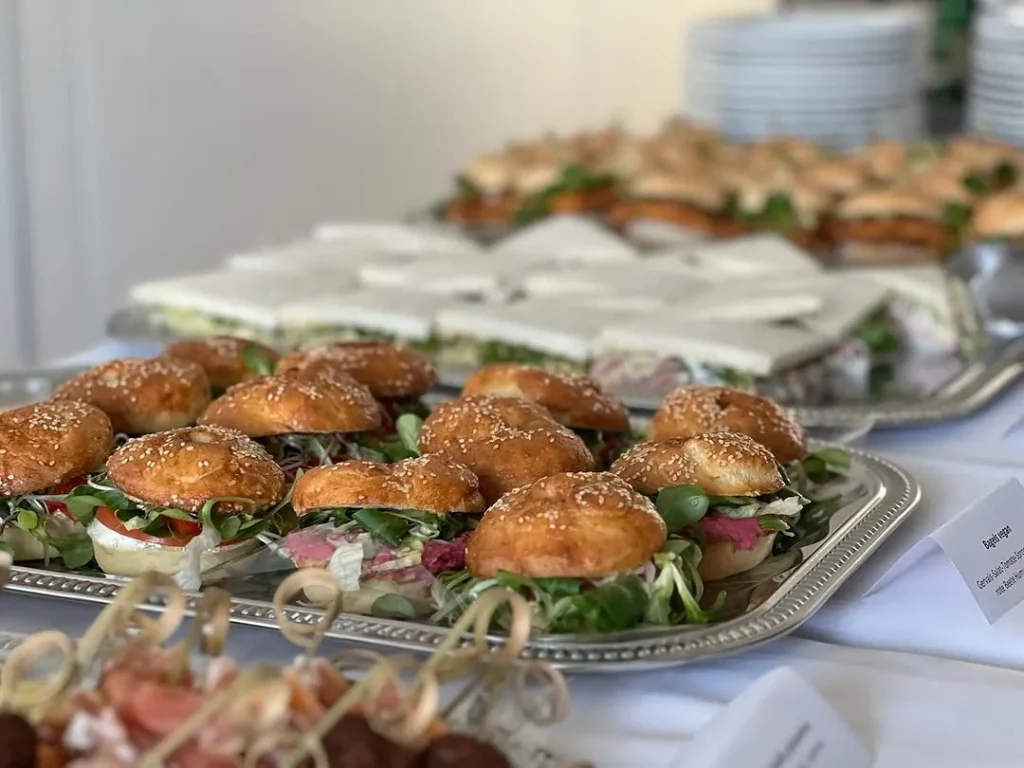 Servierplatten mit belegten Mini-Weckerln und kleinen Sandwiches