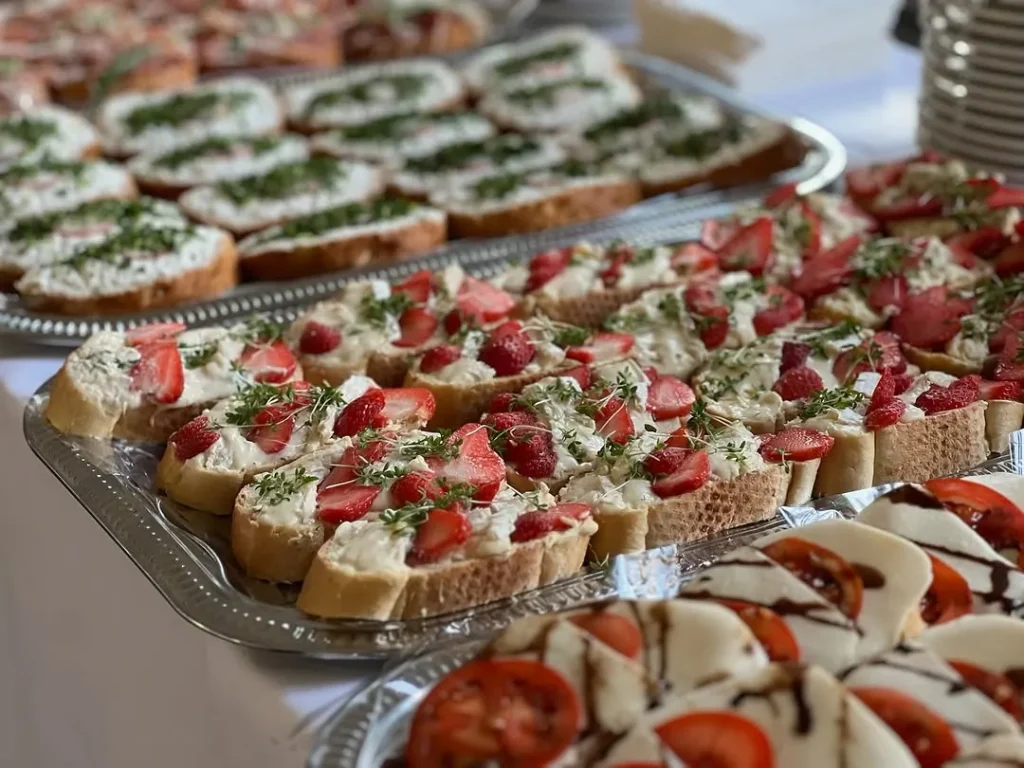 Vegetarisch belegte Brote mit Frischkäse, Kräutern, Tomaten und Gemüse auf der Servierplatte