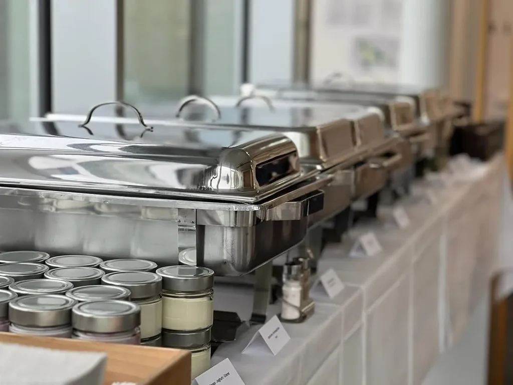 Reihe von Warmhaltebehältern mit warmen Speisen bei einem Catering-Einsatz
