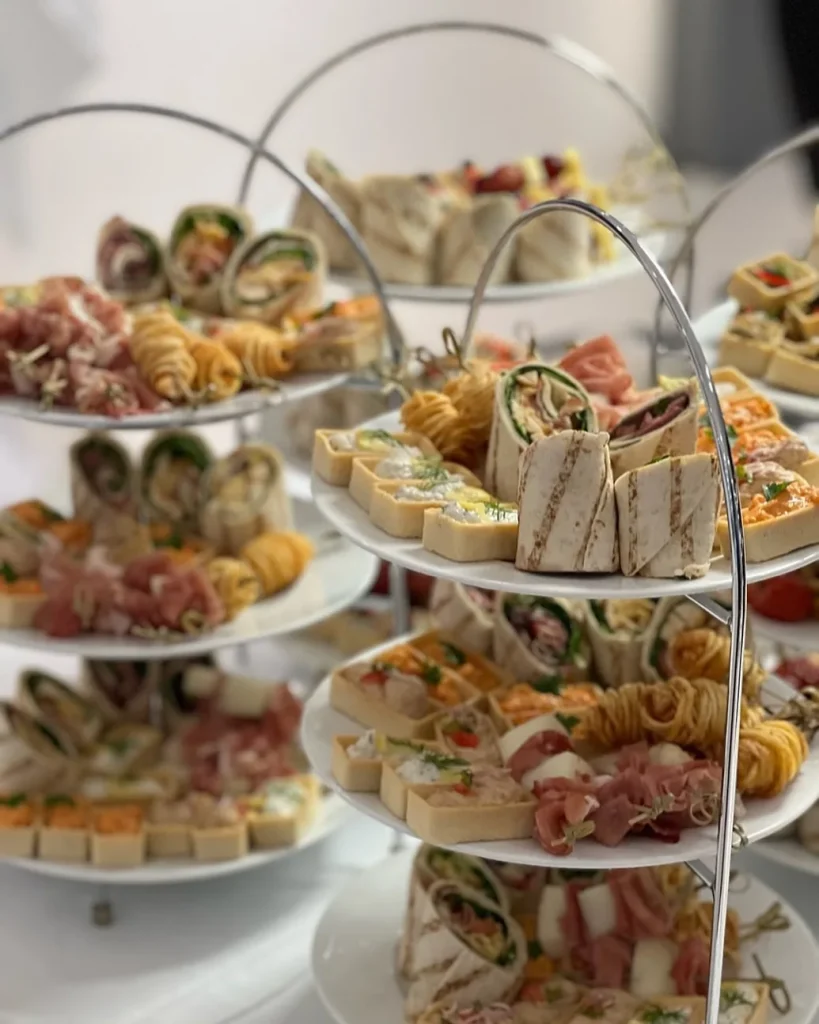 Etagere mit gefüllten Wraps, Tramezzini und kleinen Sandwiches