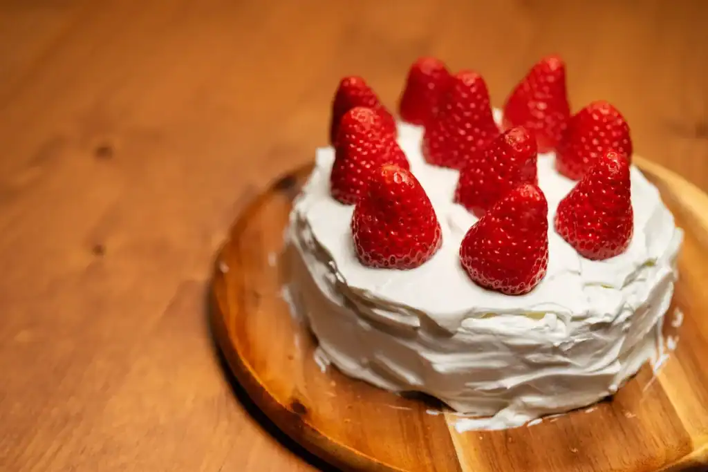 Kleiner Erdbeerkuchen mit Sahne und frischen Erdbeeren.