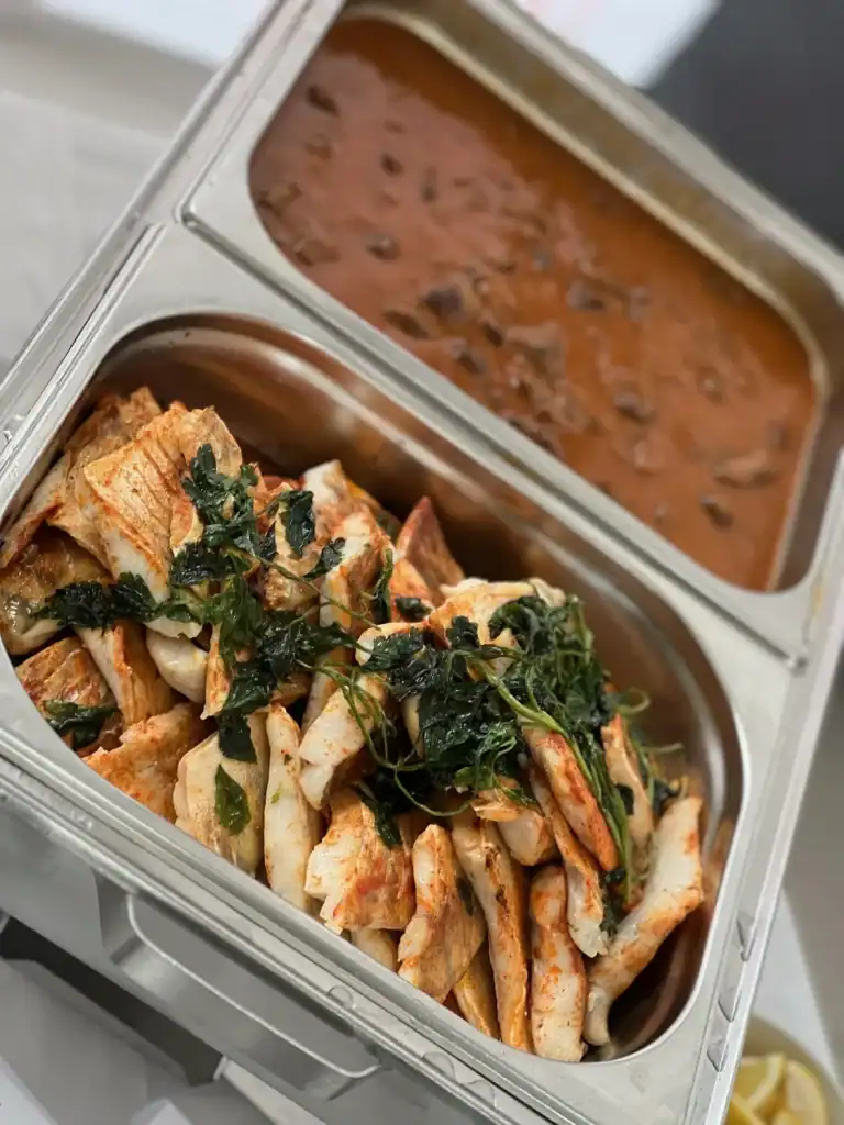 Fischfilets mit Kräutern und Beilagen in Buffet-Station.