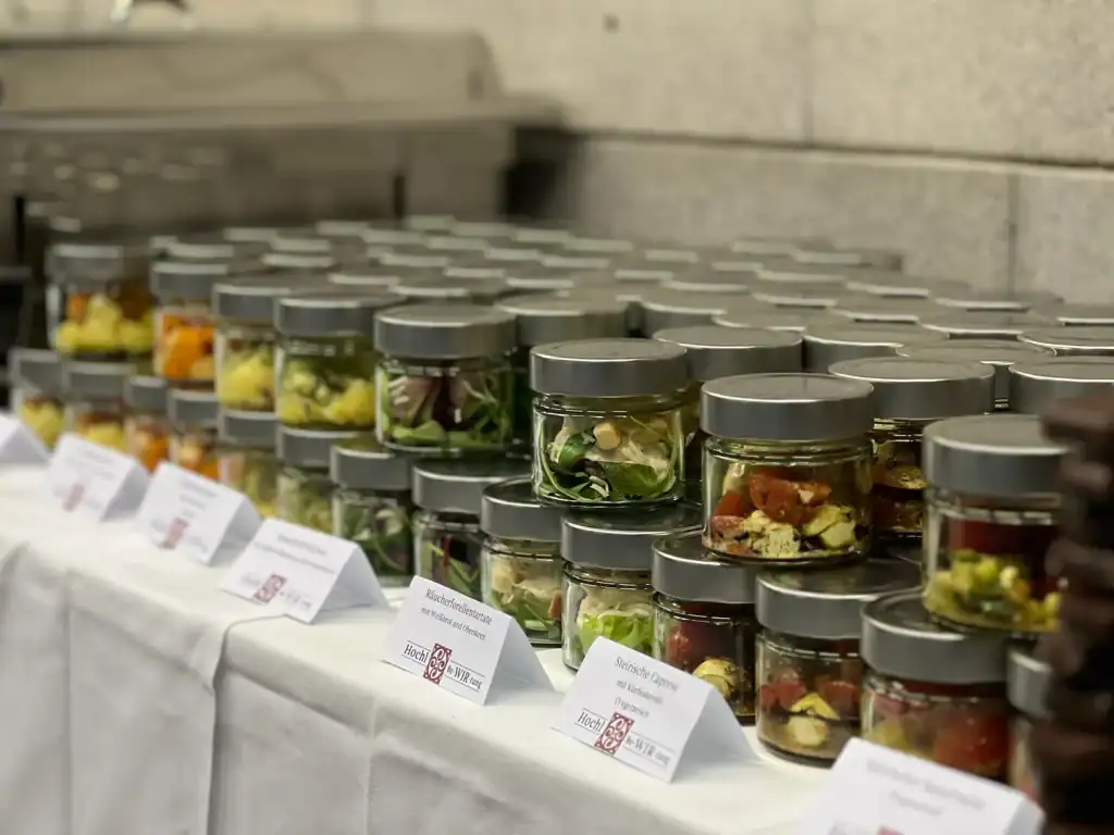 Verschiedene eingelegte Lebensmittel in Gläsern auf einem Marktstand.
