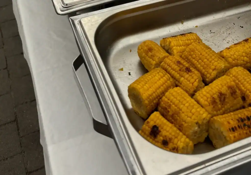 Gegrillter Mais in Edelstahl-Behälter auf Buffet.