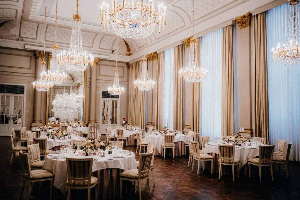 Festsaal mit Kronleuchtern und gedeckten Tischen