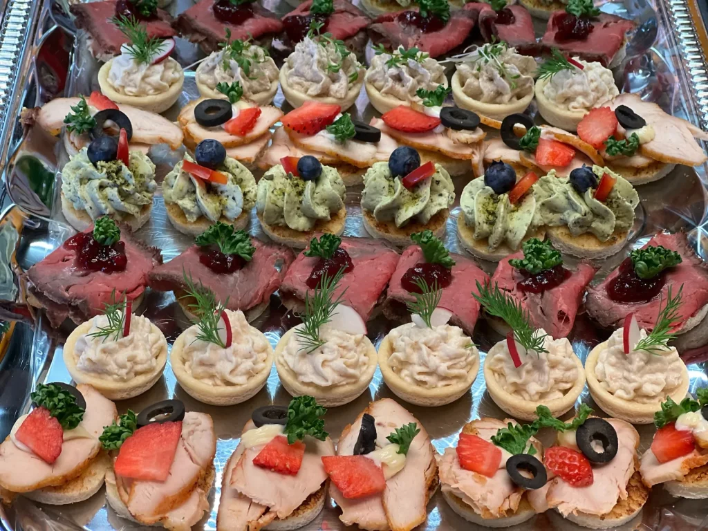 Canapés und Tartelettes in Reihen auf der Servierplatte