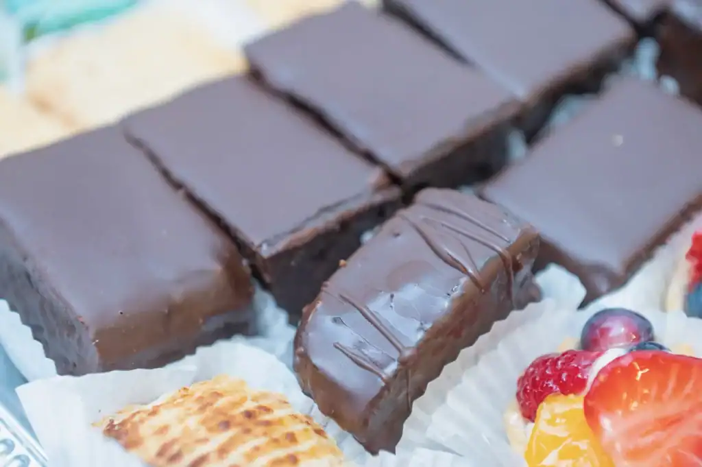 Verschiedene Schokoladenriegel und Fruchtdesserts auf einem Tablett.
