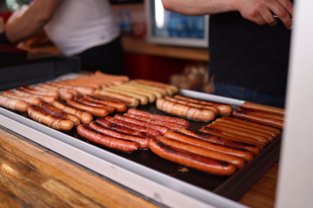 Würstel auf einer flachen Grillplatte (Plancha)