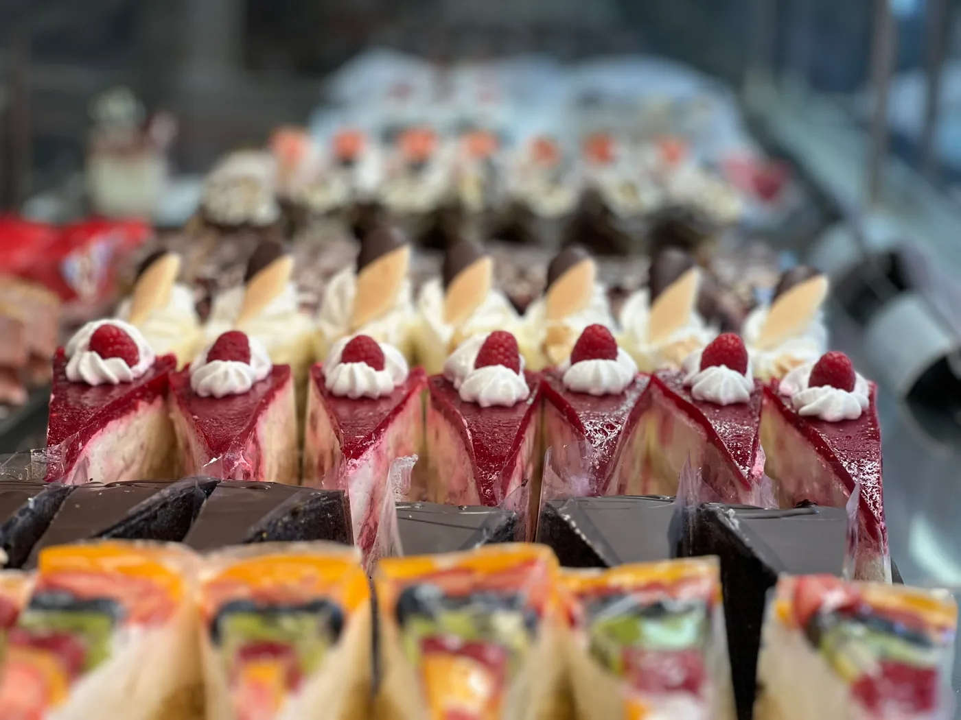 Torten mit Beeren und Sahne in der Vitrine