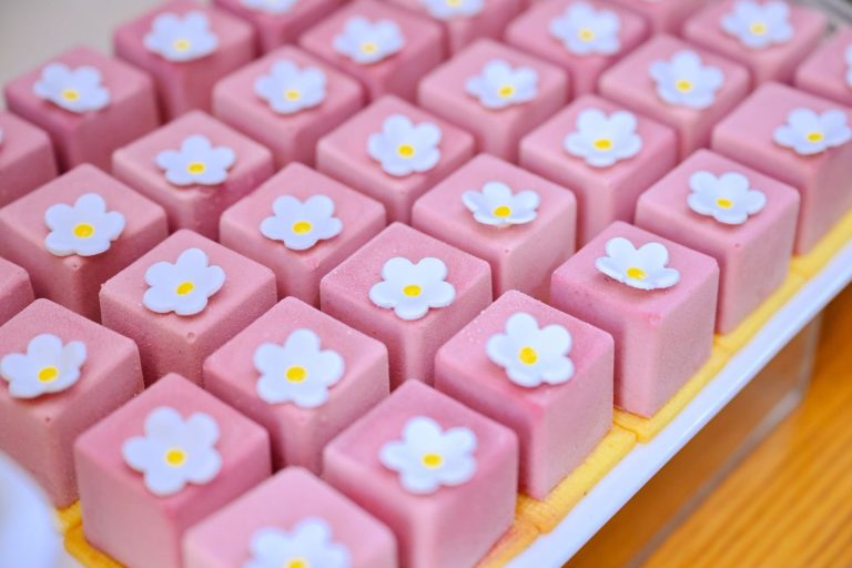Rosa glasierte Punschkrapfen auf einem Blech