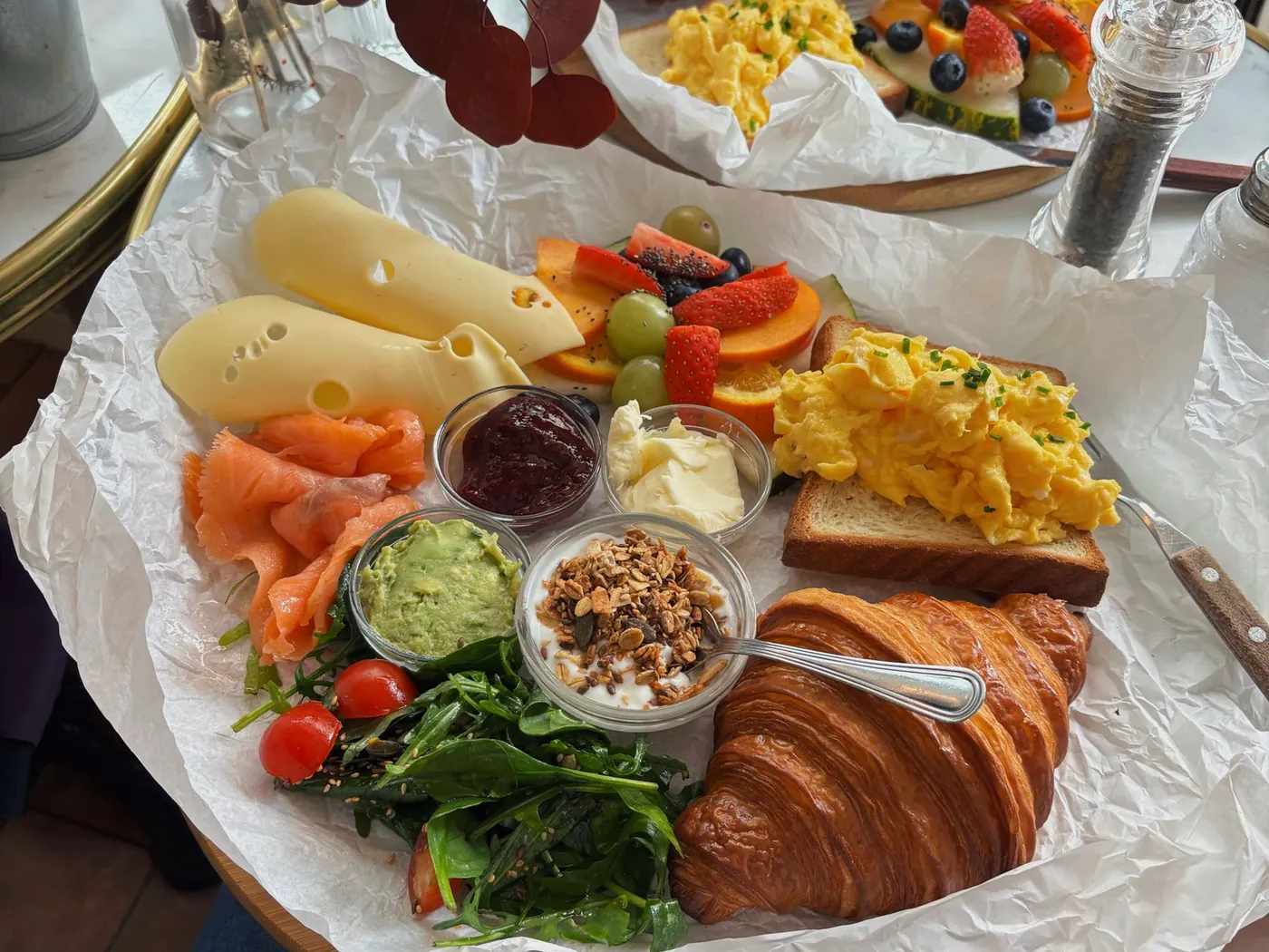 Frühstücksbrett mit Gebäck, Käse, Eierspeise und Marmelade